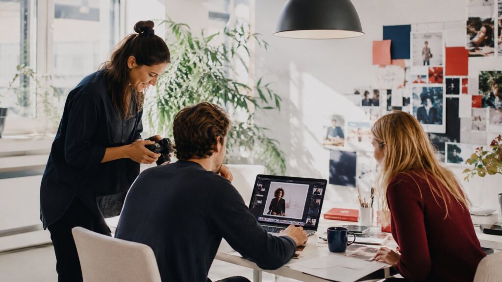 Contentmaker werkt in een modern kantoor aan visuele content met camera en laptop