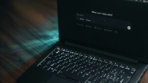 Laptop met een AI-assistent op het scherm die vraagt waarmee hij kan helpen