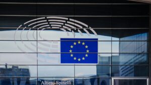 Gevel van het Europees Parlement in Brussel met de Europese vlag en het logo van het parlement